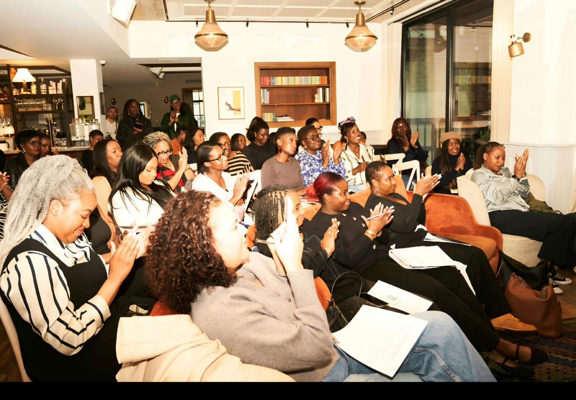 A full room of women listening and applauding